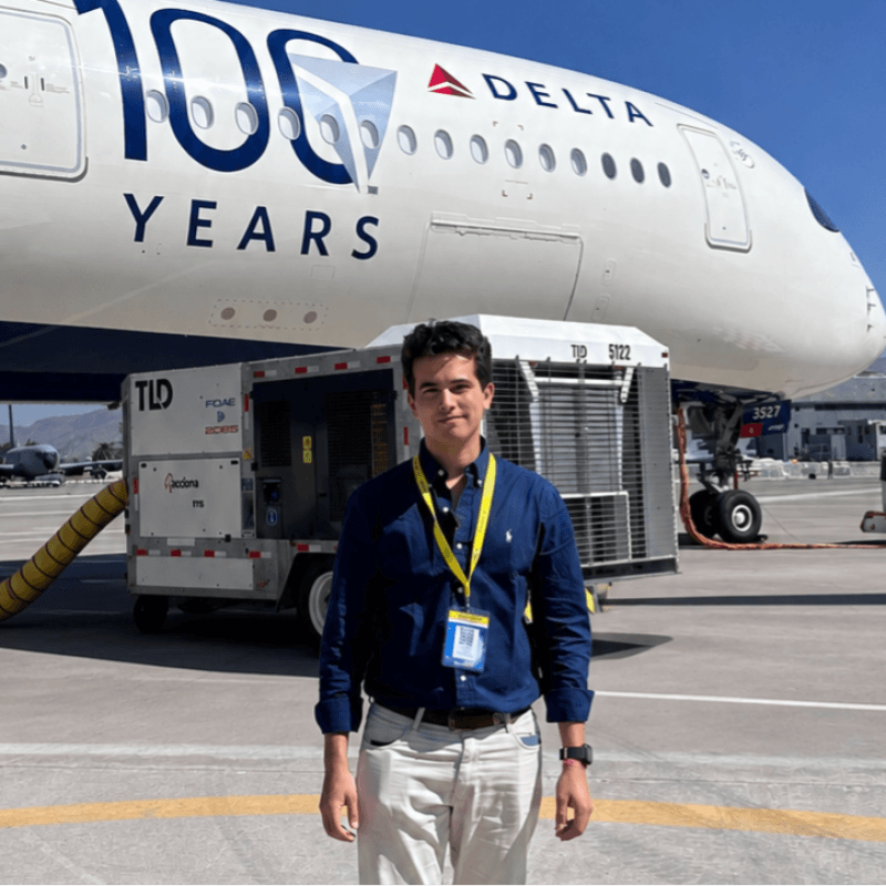 Gabriel Alvarez frente a un avión Delta en plataforma aeroportuaria